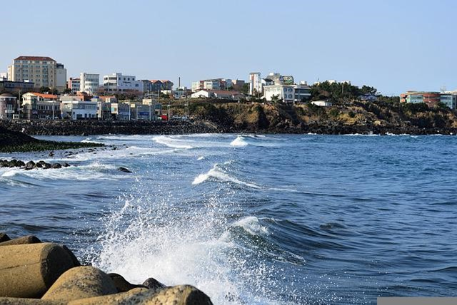 A large body of water with jeju in the background.