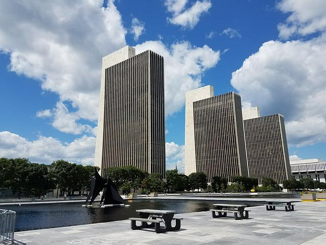 A row of tall buildings with picnic tables in front of them in albany
