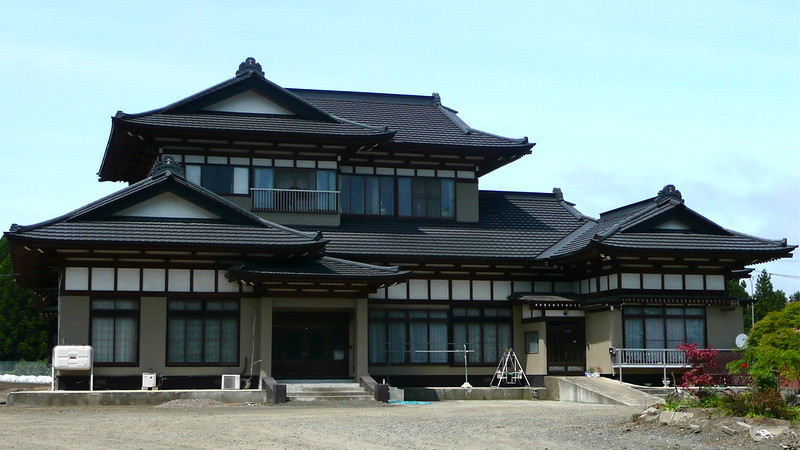 A large house with a lot of windows and a black roof in Amori City