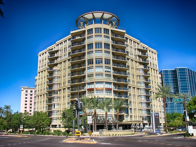 A large building with a lot of windows is sitting on the corner of a city street in phoenix