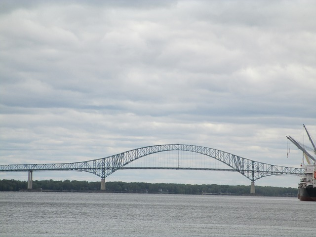 A bridge over a body of water with a cloudy sky in the background in Trois-Riviéres