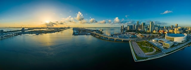 An aerial view of the miami skyline overlooking a body of water at sunset.