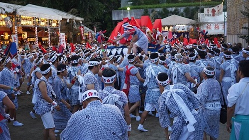 A large group of people are dancing in a ceremony at Osaka Tenmangu Shrine