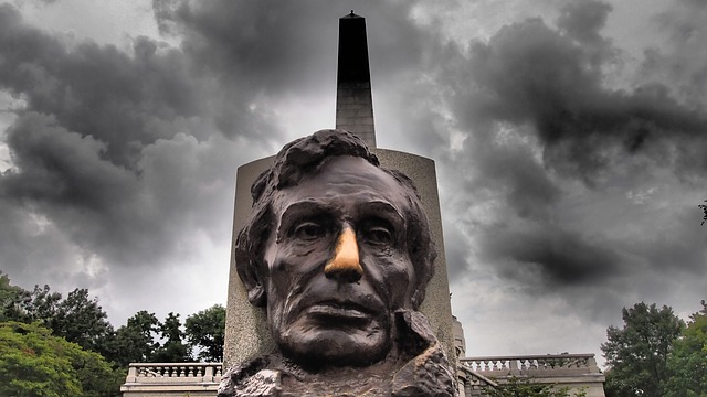 A statue of abraham lincoln is standing in front of a cloudy sky in springfield