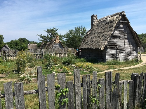 A wooden house with a thatched roof behind a wooden fence in Plymouth