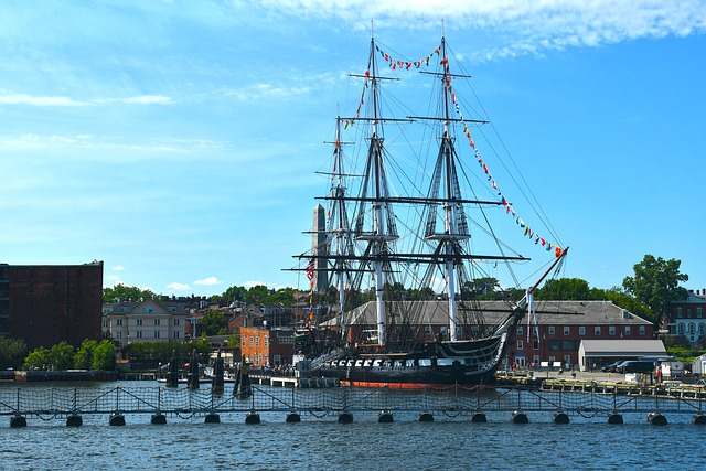 A large, historic ship is docked in boston harbor.