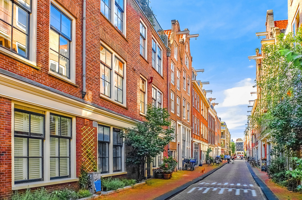 A row of brick buildings along a narrow street in Amsterdam.