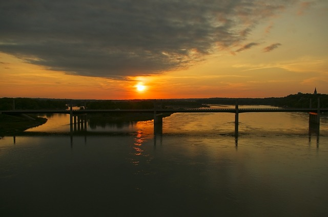 The sun is setting over a bridge over a body of water in the yankton reservation