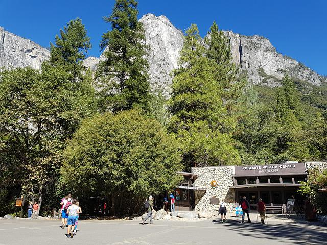 A group of people are walking in front of a building in yosemite valley