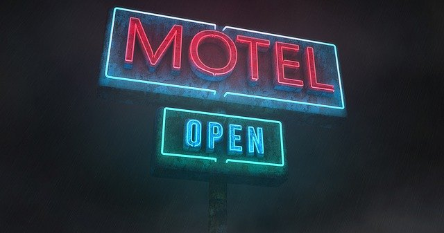 A neon sign for a motel that is open at night