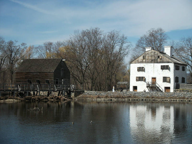 Two buildings are next to a body of water in Philipsburg Manor