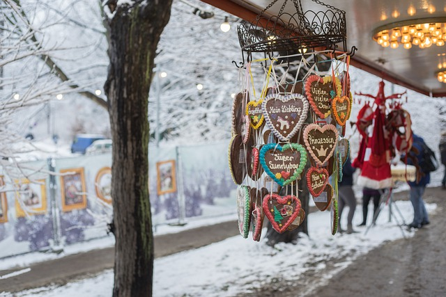 A christmas market with gingerbread hearts hanging from a pole in the snow.