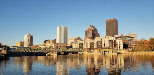 The Rochester city skyline is reflected in a body of water.