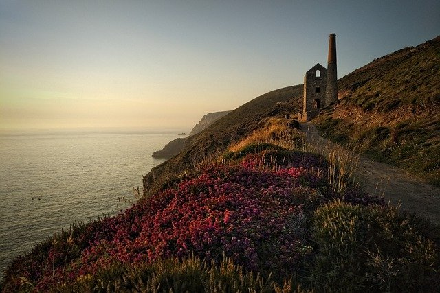 There is a building on the cliff overlooking the ocean in Cornwall