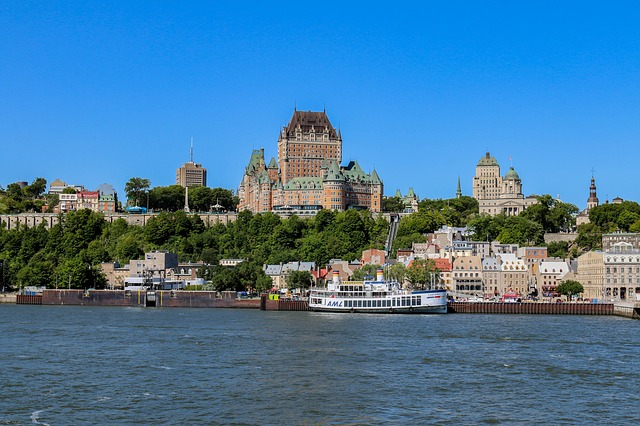 A large building is sitting on top of a hill overlooking a body of water in Quebec City