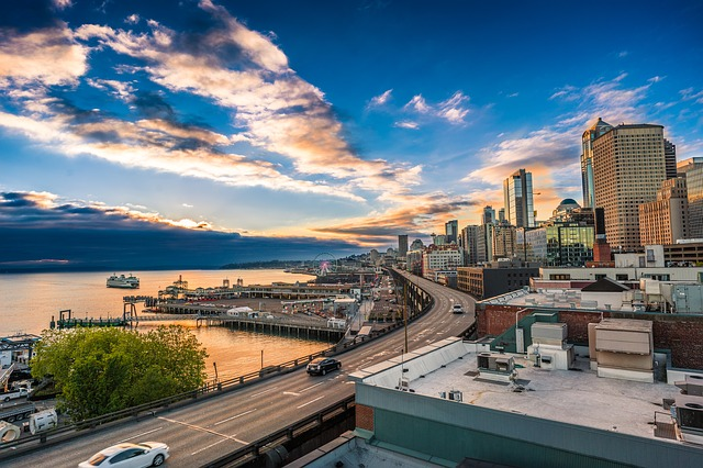 An aerial view of seattle at sunset with a highway going through it.