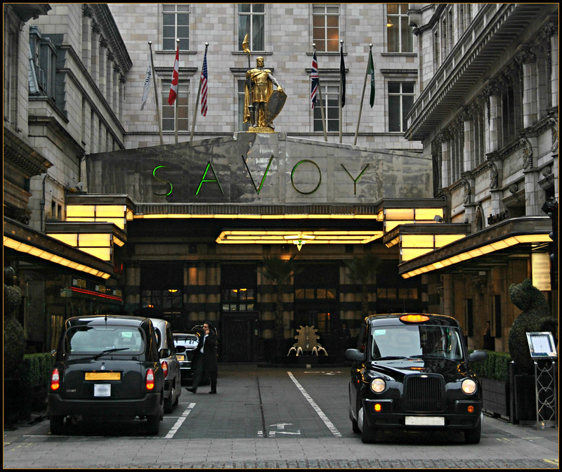 Two black cabs are parked in front of the savoy hotel in London