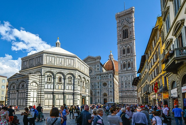 A group of people are standing in front of a large building in Tuscany