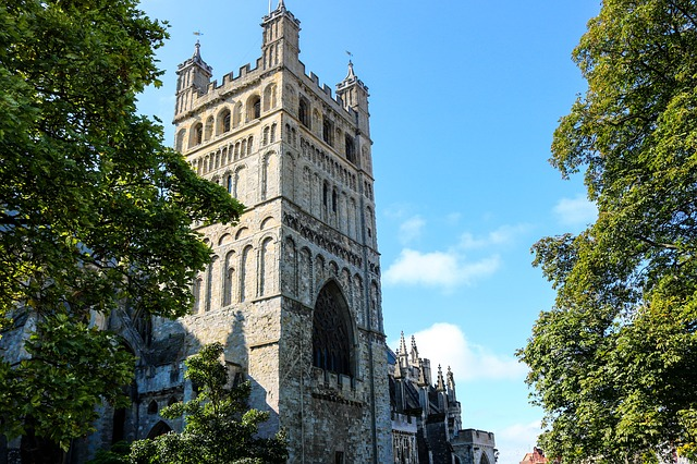 Exeter Cathedral surrounded by trees on a sunny day.