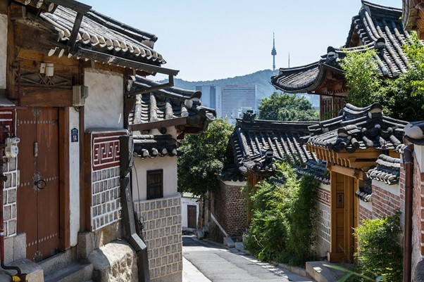 A narrow street in Seoul with a lot of buildings on it