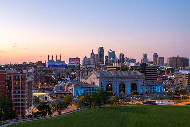 An aerial view of a city skyline at sunset with a large building in the foreground.