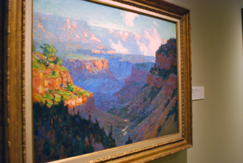 A framed painting of the grand canyon is hanging on a wall in the phoenix art museum
