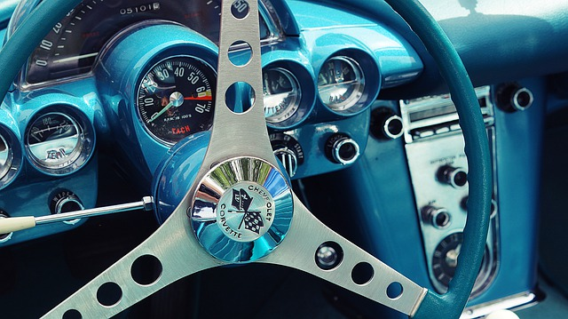 A close up of a blue car steering wheel and dashboard