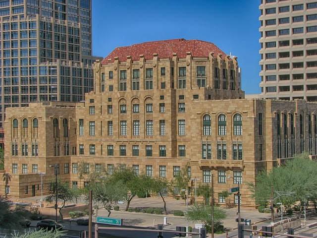 A large, historic building with a red tile roof is in the middle of Phoenix