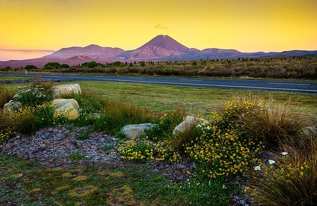 There is a mountain in the background and a road in the foreground.