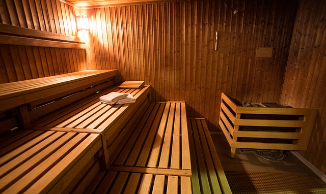 A wooden sauna with benches and a towel on the floor.