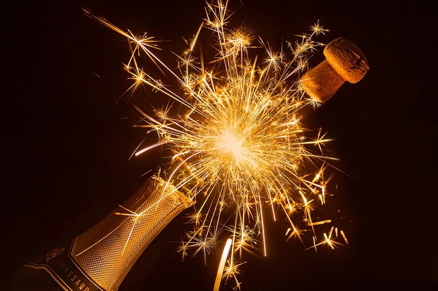 A bottle of champagne with sparklers coming out of it.