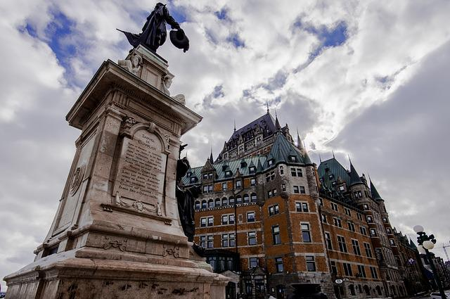 A large building with a statue in front of it in quebec city.