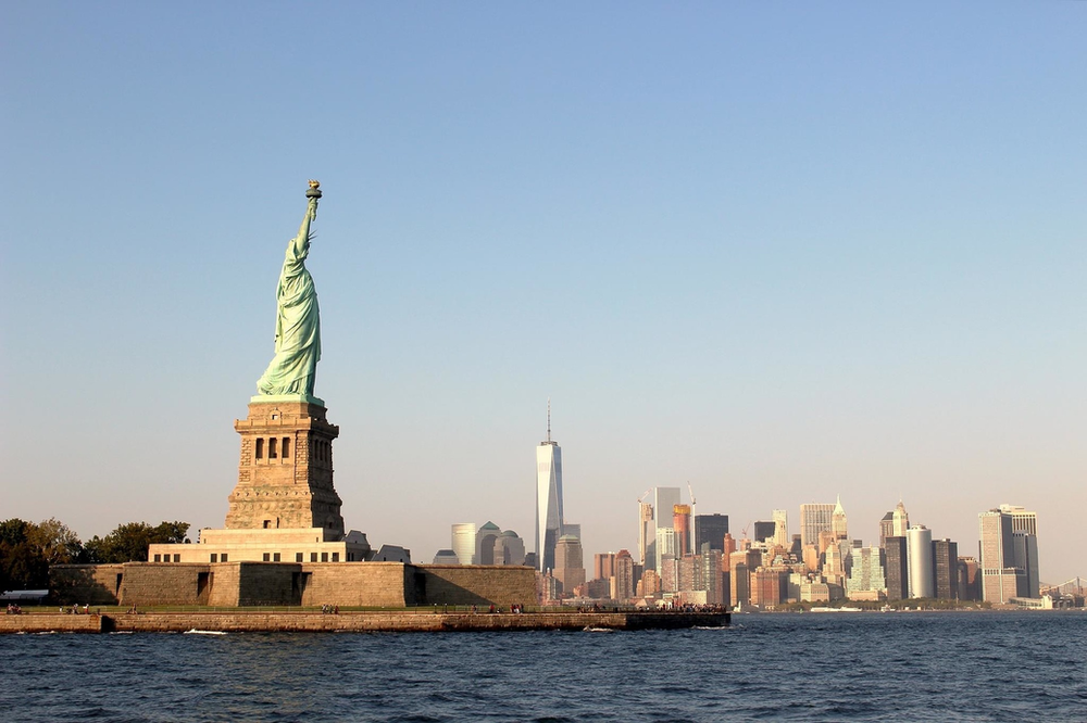 The statue of liberty is in the middle of a body of water