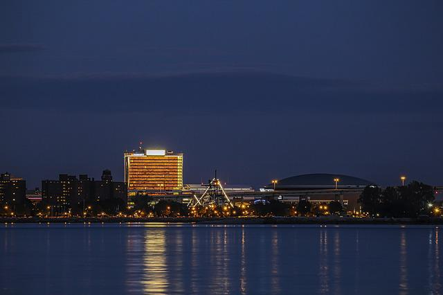 The Buffalo skyline at night with a large body of water in the foreground.