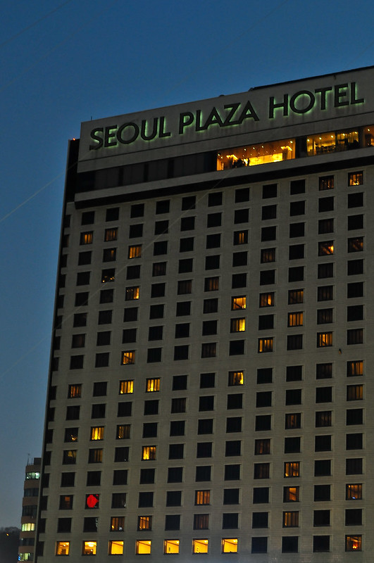 The seoul plaza hotel is lit up at night