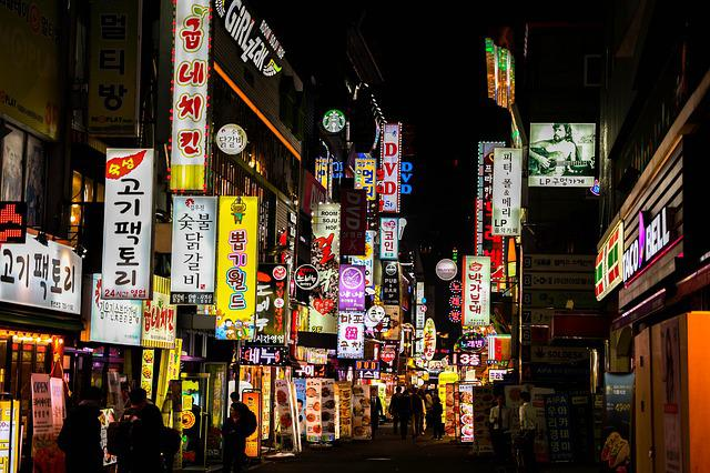 A busy seoul street at night with a lot of signs on the buildings