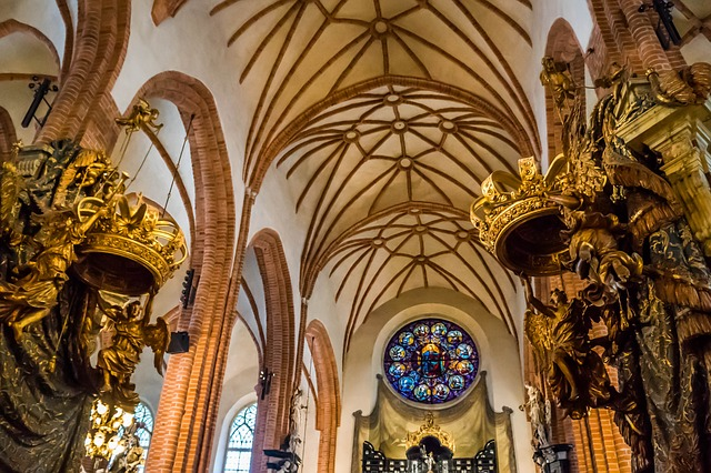 The inside of stockholm cathedral with arches and a stained glass window