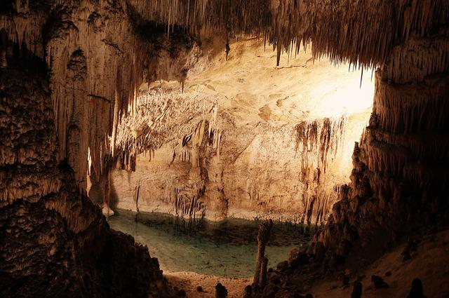 A cave with a pool of water in the middle of it in carlsbad caverns np