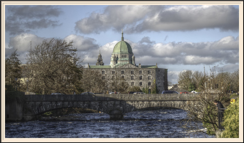 A bridge over a river with Galway Cathedral in the background