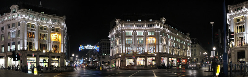A London street at night with a lot of buildings lit up