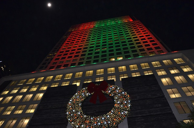 A christmas wreath is in front of a tall building in miami