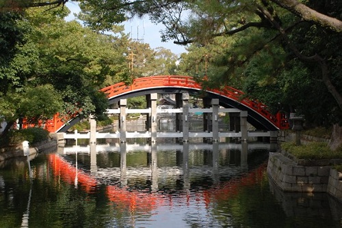 A bridge over a body of water surrounded by trees at Sumiyoshi Taisha