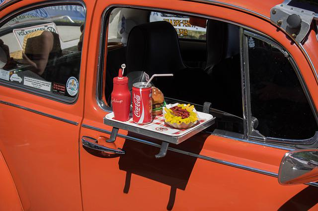 An orange car with a tray of food and a can of coca cola