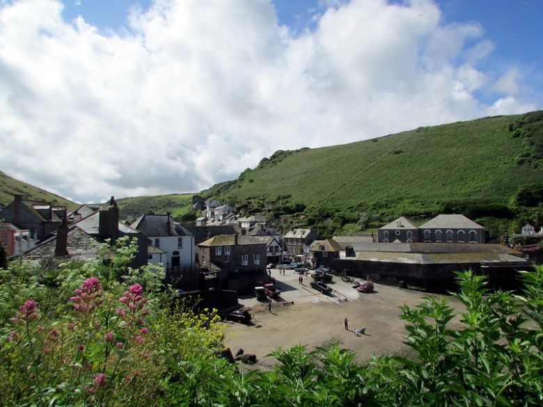 A view of the small town of Port Isaac with a hill in the background