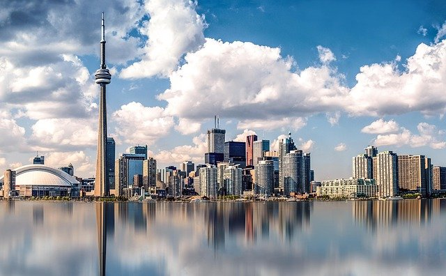 The skyline of Toronto is reflected in the water.
