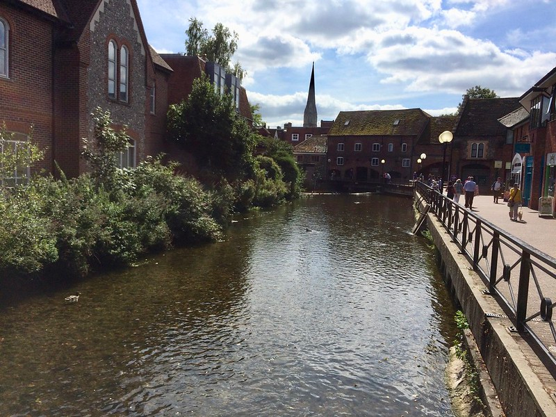 A river running through salisbury with buildings in the background