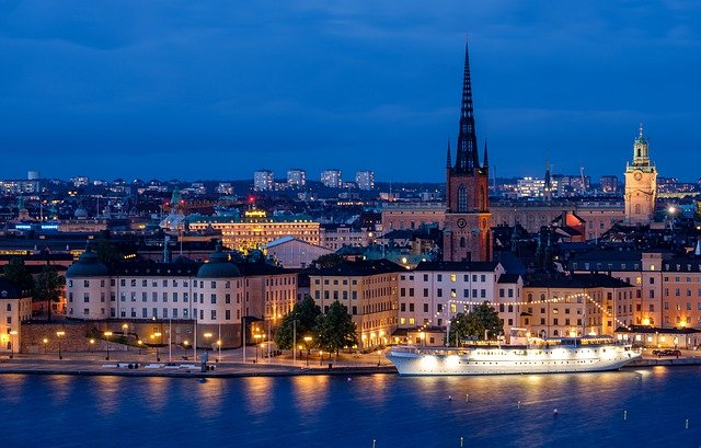 A large ship is docked in stockholm harbor at night.