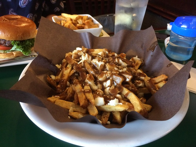 A plate topped with french fries and gravy, known as poutine