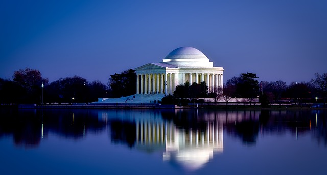 The Washington Monument is reflected in the water at night.