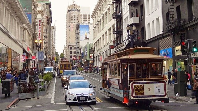 A cable car is driving down a San francisco street.